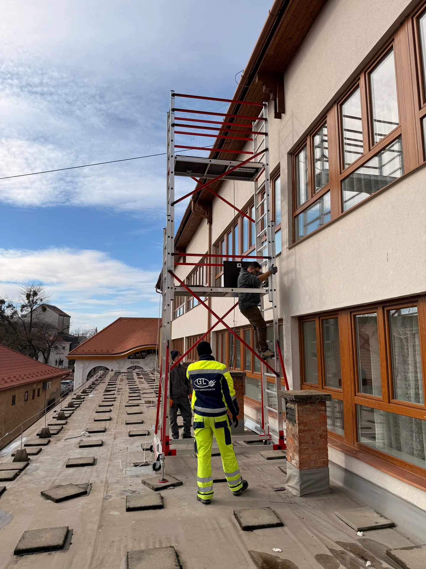 GL Electrical munkatársai és állványzat egy épület mellett.